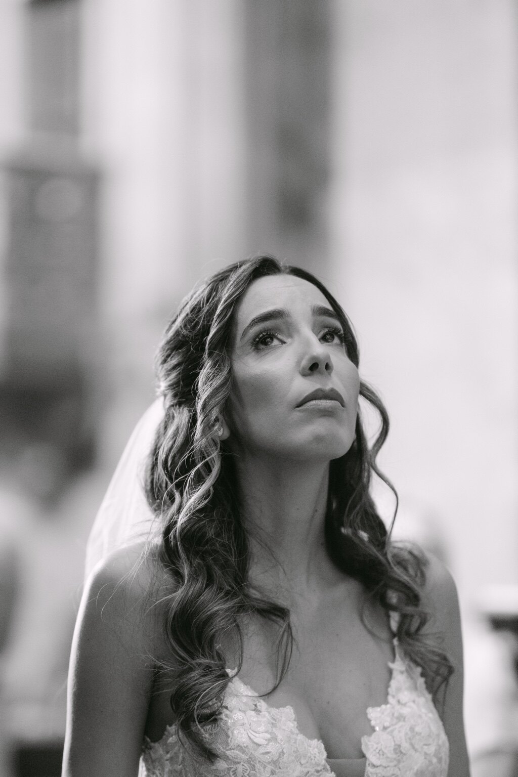 Retrato a preto e branco da noiva a olhar para cima durante a cerimónia.