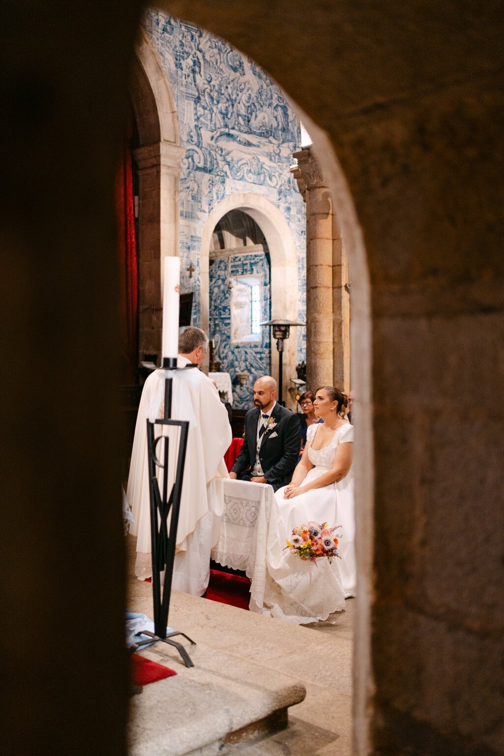A saída da cerimónia enquadrada por um arco de pedra da igreja.